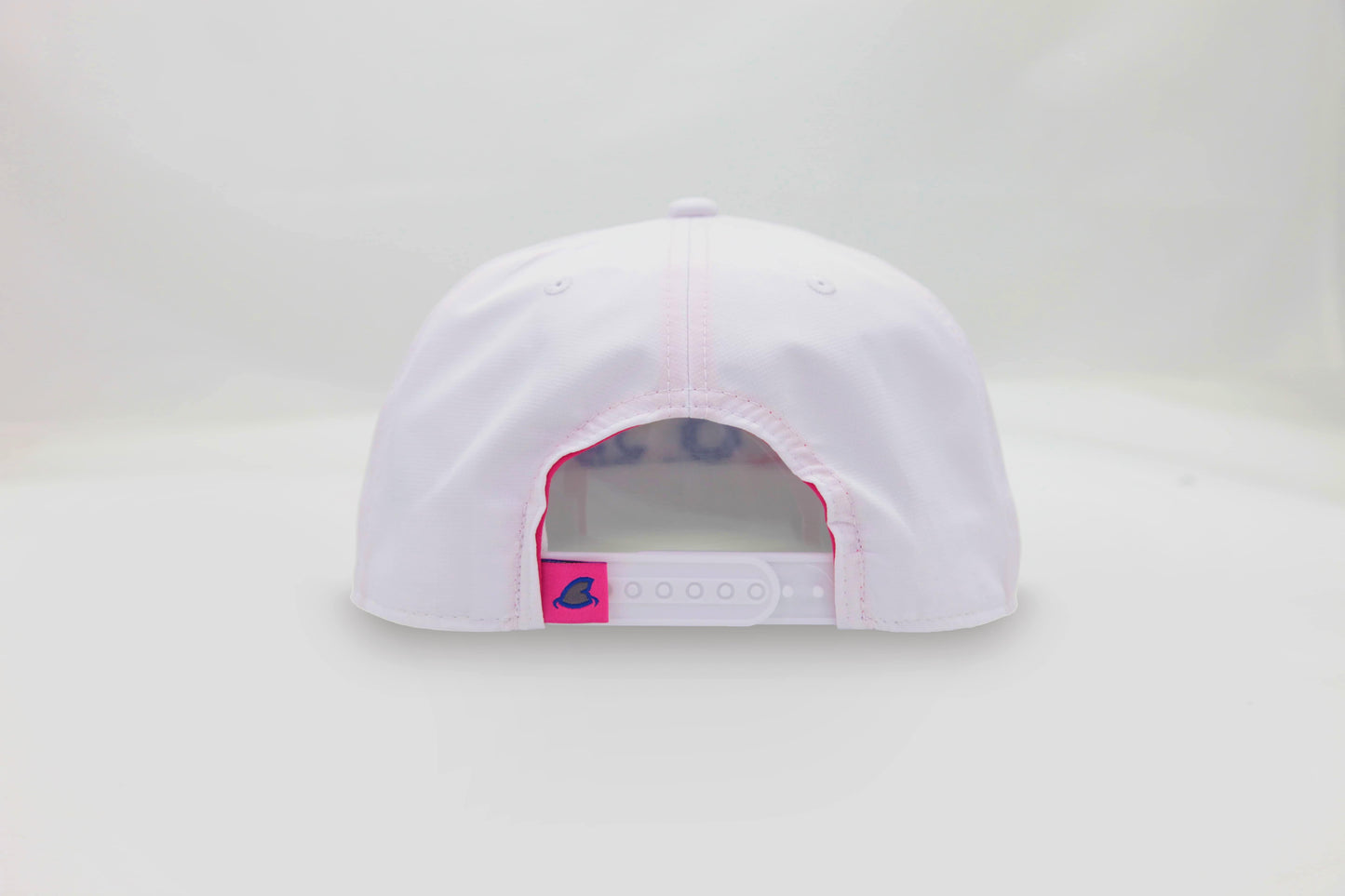 Back view of The Ice Dangerous ’93 Hat – white cap with adjustable strap and small, pink loop tag accent featuring the Maxwell Sharkey shark fin icon.