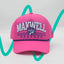 Front view of The Sunset Slasher ’93 Hat – hot pink rope hat with Maxwell Sharkey written in blue and white, and the Maxwell Sharkey mascot nestled between the words. The hat features a blue and pink rope detailing across the brim.