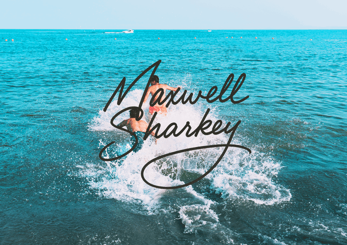 Stylized Maxwell Sharkey signature script over photo of two people jumping into bright blue ocean water with large splash.